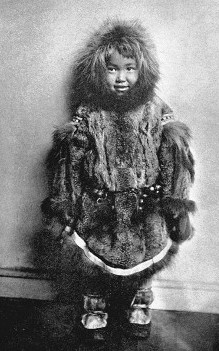 Inuit child wearing a  fur parka and mukluk boots